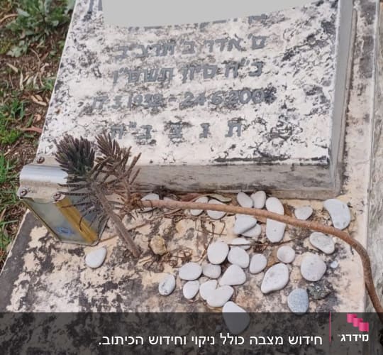 מצבה עם אבנים קטנות וענף יבש מונחים עליה